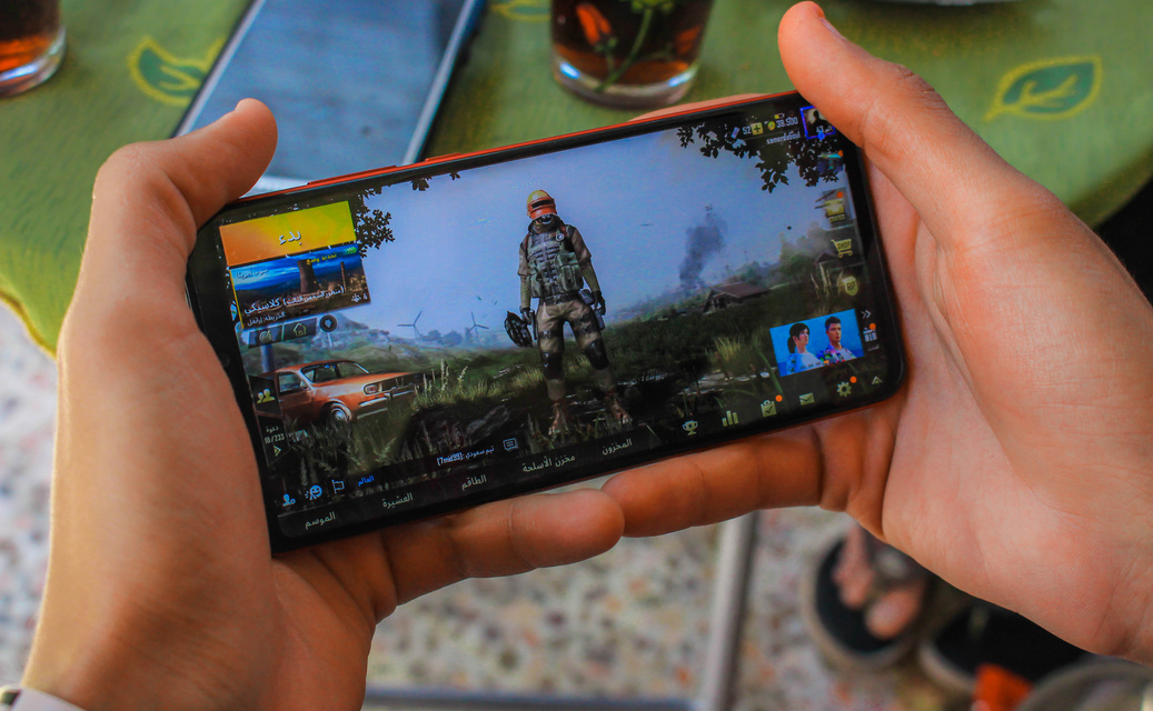 Crop faceless man playing video game on smartphone